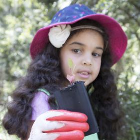 Girl holding seedling she has planted