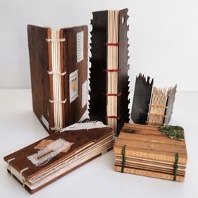 A number of coptic bound books in varying sizes and materials